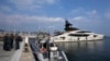 Foto ilustrasi yang menujukkan sejumlah anggota kepolisian finansial Italia berdiri di dekat kapal pesiar "Lady M," yang dimiliki oleh oligarki Rusia, Alexei Mordashov, di pelabuhan Imperia, Italia, pada 5 Maret 2022. (Foto: AP/Antonio Calanni)