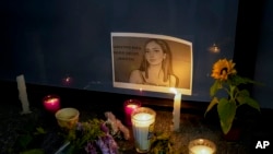 FILE - Candles and flowers surround an image of Debanhi Escobar during a protest against the disappearance of her and other missing women in Mexico City, April 22, 2022.