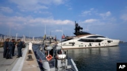 Polisi Keuangan Italia berdiri di samping kapal pesiar "Lady M", milik oligarki Rusia Alexei Mordashov, berlabuh di pelabuhan Imperia, Italia, Sabtu, 5 Maret 2022. (Foto: AP)