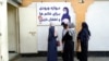 FILE - Afghan women stand outside an amusement park, in Kabul, Nov. 10, 2022. The Taliban banned women from using gyms and parks in Afghanistan, part of their crackdown on women's rights and freedoms.