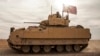 FILE - American soldiers drive a Bradley Fighting Vehicle during a joint exercise with Syrian Democratic Forces in northeastern Syria, Dec. 8, 2021. The U.S. will be sending Bradleys to aid Ukraine in its battle against Russian invaders.