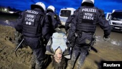 Police officers carry a demonstrator during a protest against the expansion of a coal mine in Luetzerath, Germany, Jan. 14, 2023.