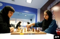 Pecatur Iran Mitra Hejazipour (kiri) dan Sara Khademalsharieh bermain di Federasi Catur di ibu kota Teheran pada 10 Oktober 2016. (Foto: AFP)