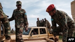 FILE - Somali National Army Personnel climb in to pickup trucks at Baidoua airport in Baidoa, Somalia, on Nov. 9, 2022. 