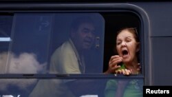 Supporters of Brazil's former President Jair Bolsonaro yell from buses leave the National Academy of the Federal Police after a camp set by supporters was dismantled in front of the Army Headquarters, in Brasilia, Brazil, Jan. 10, 2023.