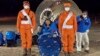 In this photo released by Xinhua News Agency, astronaut Chen Dong waves as he sits outside the re-entry capsule of the Shenzhou-14 manned space mission after it lands successfully at the Dongfeng landing site. 