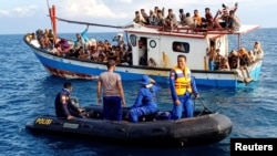 FOTO FILE: Pengungsi Rohingya yang diselamatkan oleh nelayan, terlihat di atas kapal di belakang kapal patroli dekat pantai Seunuddon, Aceh Utara, 24 Juni 2020. (Antara Foto/Rahmad/via REUTERS)