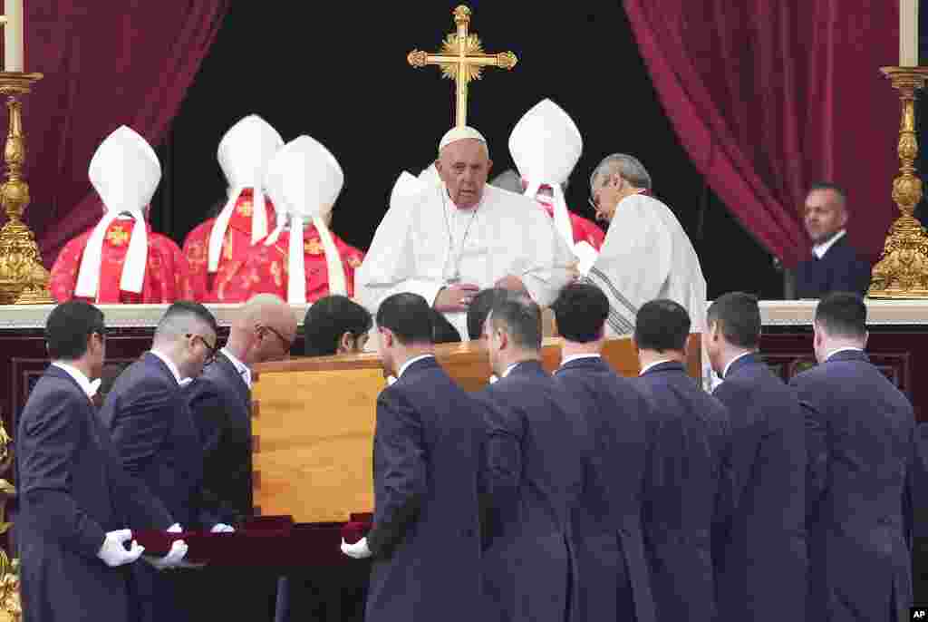 Pope Francis looks on as the coffin of late Pope Emeritus Benedict XVI is carried for a funeral Mass in St. Perter's Square at the Vatican, Jan. 5, 2023.