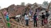Warga mengamati reruntuhan rumah mereka yang rusak parah akibat gempa Senin di Cianjur, Jawa Barat, Selasa, 22 November 2022. (AP/Tatan Syuflana)