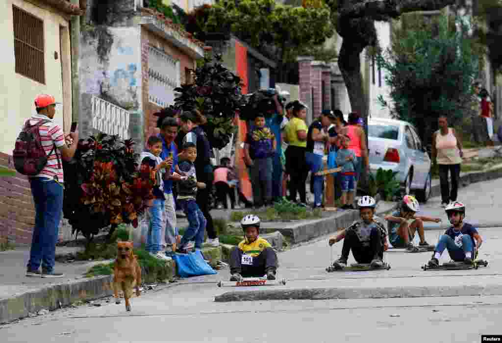 Children participate in a traditional street race with wooden makeshift carts called "carruchas", in Caracas, Venezuela, Dec. 17, 2022.
