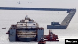 Kapal Costa Concordia didorong ke pelabuhan Genoa, Italia barat laut, di mana kapal tersebut akan dipreteli, 27 Juli 2014. 