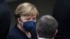 FILE - Former German Chancellor Angela Merkel talks with the former leader of Germany's Christian Democratic Union (CDU) Armin Laschet in Berlin on Feb. 13, 2022.