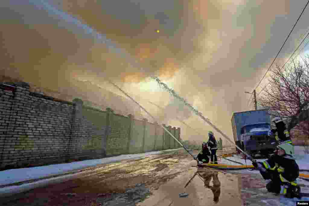Rescuers work at a site of a warehouse burned after shelling in Kharkiv as Russia's attack on Ukraine continues, March 16, 2022.