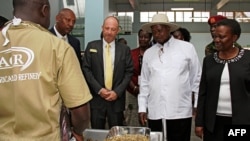 Moyi mombongo ya Belgique Alain Goetz, nkolo compagnie AGR Limited (C G) na président Yoweri Museveni ya Uganda (c) na ministre ya Energy mpe mines ya Uganda, Irene Muloni, na raffinerie ya AGR na Entebbe, 20 février 2017.