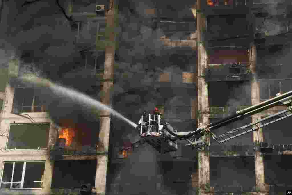 Firefighters extinguish a fire in an apartment building damaged by Russian shelling in Kyiv, Ukraine, March 15, 2022. Russia’s offensive in Ukraine has edged closer to central Kyiv with a series of strikes hitting a residential neighborhood as the leaders of three NATO member countries planned a visit to the embattled capital.