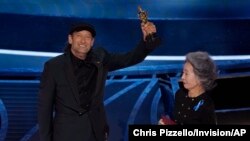 Aktor Youn Yuh-jung (kanan) menyampaikan penghargaan Oscar untuk Troy Kotsur dalam kategori pemeran pendukung pria terbaik lewat perannya di film "CODA" pada ajang Oscar yang digelar di Los Anggeles, pada 27 Maret 2022. (Foto: AP/Chris Pizzello)