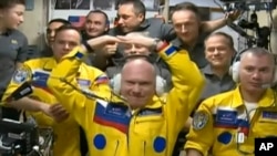 Ruski kosmonauti Oleg Atremiev (u sredini), Denis Matvev (desno) i Sergej Korsakov poziraju među drugim članovima ekspedicije na Međunarodnoj svemirskoj stanici ISS, 18. marta 2022.