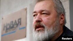 FILE - Russian investigative newspaper Novaya Gazeta's editor-in-chief Dmitry Muratov, one of the 2021 Nobel Peace Prize winners, speaks with journalists in Moscow, Russia, Oct. 8, 2021.