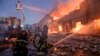 Petugas pemadam kebakaran Ukraina memadamkan kobaran api di gudang pasca ledakan bom di Kyiv, Ukraina, Kamis, 17 Maret 2022. (Foto: AP)