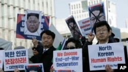 Para pembelot dari Korea Utara dan pedemo dari Korea Selatan menunjukkan foto Pemimpin Korea Utara Kim Jong Un dalam demo di Seoul, Korsel meminta AS membahas isu HAM dalam pertemuan tingkat tinggi Presiden AS Donald Trump dan pemimpin Korea Utara, Kim Jong Un, 11 Juni 2019.
