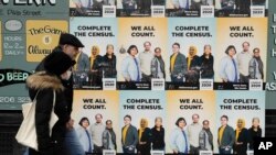 FILE - In this April 1, 2020 file photo, people walk past posters encouraging participation in the 2020 Census in Seattle's Capitol Hill neighborhood. 