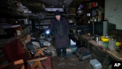 A woman shows a shelter in her basement where she and her neighbors have been living for a month, hiding from the Russian shelling in Kharkiv, Ukraine, March 26, 2022.
