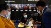 Felicia Price ( tengah) berbicara kepada Damien Walker (kanan), dan istrinya Raquel tentang peluang kerja dengan Program Head Start dan Early Head Start, selama pameran pekerjaan Miami-Dade County, Rabu, 23 Februari 2022, di pusat kota Miami. (AP/Rebecca Blackwell)