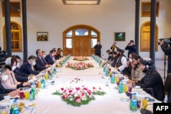 Delegasi China di bawah pimpinan Menlu Wang Yi (kiri) melakukan pembicaraan dengan delegasi Taliban di bawah Menlu Amir Khan Muttaqi di Kabul, Kamis (24/3).