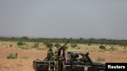 FILE - Niger's army soldiers ride on a pickup truck near Agadez, Niger, Oct. 29, 2019.