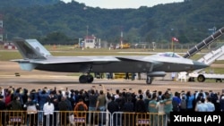 在第14屆珠海航空航天展覽會上，中國製造的殲-20重型隱身戰鬥機停在跑道上供參觀者拍照。（2022年11月8日）