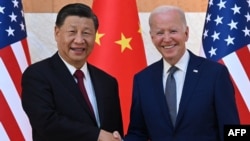 资料照片：美国总统乔·拜登(右)和中国国家主席习近平(左)2022年11月14日在印度尼西亚度假胜地巴厘岛努沙杜瓦举行的G20峰会期间握手。（法新社图片）