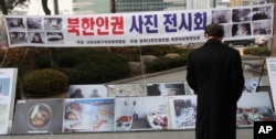 FILE - A man watches photos showing North Korean children suffering from famine at a photo exhibition in Seoul, South Korea, Feb. 27, 2014.