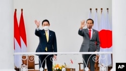 2022年4月29日，日本首相岸田文雄（左）与印尼总统维多多在印尼西爪哇茂物市总统府会面时向人群挥手致意。（照片由印尼总统府发布。）
