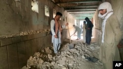People inspect the inside of a mosque following a suicide bombers attack in the city of Kandahar, southwest Afghanistan, Oct. 15, 2021.