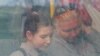 People are seen through a bus window as civilians from Mariupol, including evacuees from Azovstal steel plant, travel in a convoy to Zaporizhzhia, during Ukraine-Russia conflict in the Donetsk Region, Ukraine, May 2, 2022. 