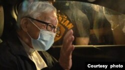 已经解散的“612人道支援基金”信托人，天主教香港教区荣休主教陈日君枢机被警方扣留了大约六个钟头后，已经获准保释离开警署。陈日君枢机在车内向外挥手致意。 （照片来源：美国之音粤语广播听众郑先生提供）