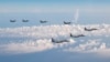 Tri borbena aviona F-15 Japanskih odbrambenih snaga, ispred, lete uz četiri borbena aviona F-16 ratnog vazduhoplovstva SAD, iznad Japanskog mora, 25. maja 2022. (Foto: AP/Generalštab japanskih odbrambenih snaga)