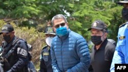 FILES - In this file photo taken on April 21, 2022, Honduran former President Juan Orlando Hernandez (C) is escorted by police officers at the Honduran National Directorate of Special Forces in Tegucigalpa before his extradition to the United States.