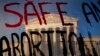Gedung Mahkamah Agung AS terlihat di balik poster bertuliskan "selamatkan Aborsi" di Washington, DC, pada 10 Mei 2022. (Foto: AFP/Stefani Reynolds)