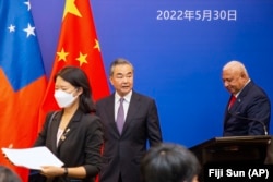 Menlu China Wang Yi, tengah, tampil di atas panggung pada pertemuan para Menlu Kepulauan Pasifik dengan PM Fiji Frank Bainimarama di Suva, Fiji, 30 Mei 2022 lalu.