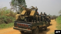 Arquivo: Veículos de soldados das FARDC (Forças Armadas da República Democrática do Congo) escoltam veículos civis que transportam mercadorias de Beni para Komanda na estrada nacional, 19 de Março de 2022