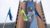 Bendera nasional Ukraina dikibarkan bersama bendera Uni Eropa di markas UE di Brussel, Belgia (foto: dok). 