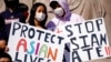 FILE - This March 20, 2021, file photo shows people holding signs as they attend a rally to support Stop Asian Hate at the Logan Square Monument in Chicago.