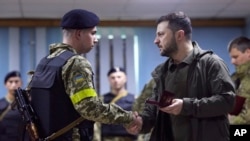 UMongameli Volodymyr Zelenskyy ngesikhathi esethekelela ibutho lakhe kwezinye indawo ezihlaselwa ngele Russia.