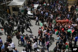Polisi Israel menghadang pelayat yang membawa peti mati jurnalis Al Jazeera yang terbunuh Shireen Abu Akleh saat pemakamannya di Yerusalem timur, 13 Mei 2022. (Foto: AP)