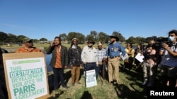 Members of the Goringhaicona Khoi Khoin Indigenous Traditional Council and protestors from surrounding communities hold placards during a picket against the construction of the new African headquarters for U.S. retail giant Amazon, in Cape Town, South Africa, Nov. 12, 2021. 
