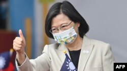FILE - Taiwan's President Tsai Ing-wen gives a thumbs-up sign as she attends a ceremony to mark the island's National Day in front of the Presidential Office in Taipei on Oct. 10, 2022. 