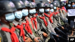 Armed riot police are seen near protesters in Naypyitaw, Myanmar on Monday, Feb. 8, 2021. 