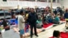 FILE - Gustavo Banda, center-right, pastor of Templo Embajadores de Jesus, Tijuana's largest migrant shelter, speaks with migrants at a shelter, Oct. 13, 2022, in Tijuana, Mexico, along the U.S. border.