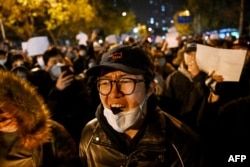 Para pengunjuk rasa berbaris di sepanjang jalan di China di Beijing pada 28 November 2022. (Foto: AFP)